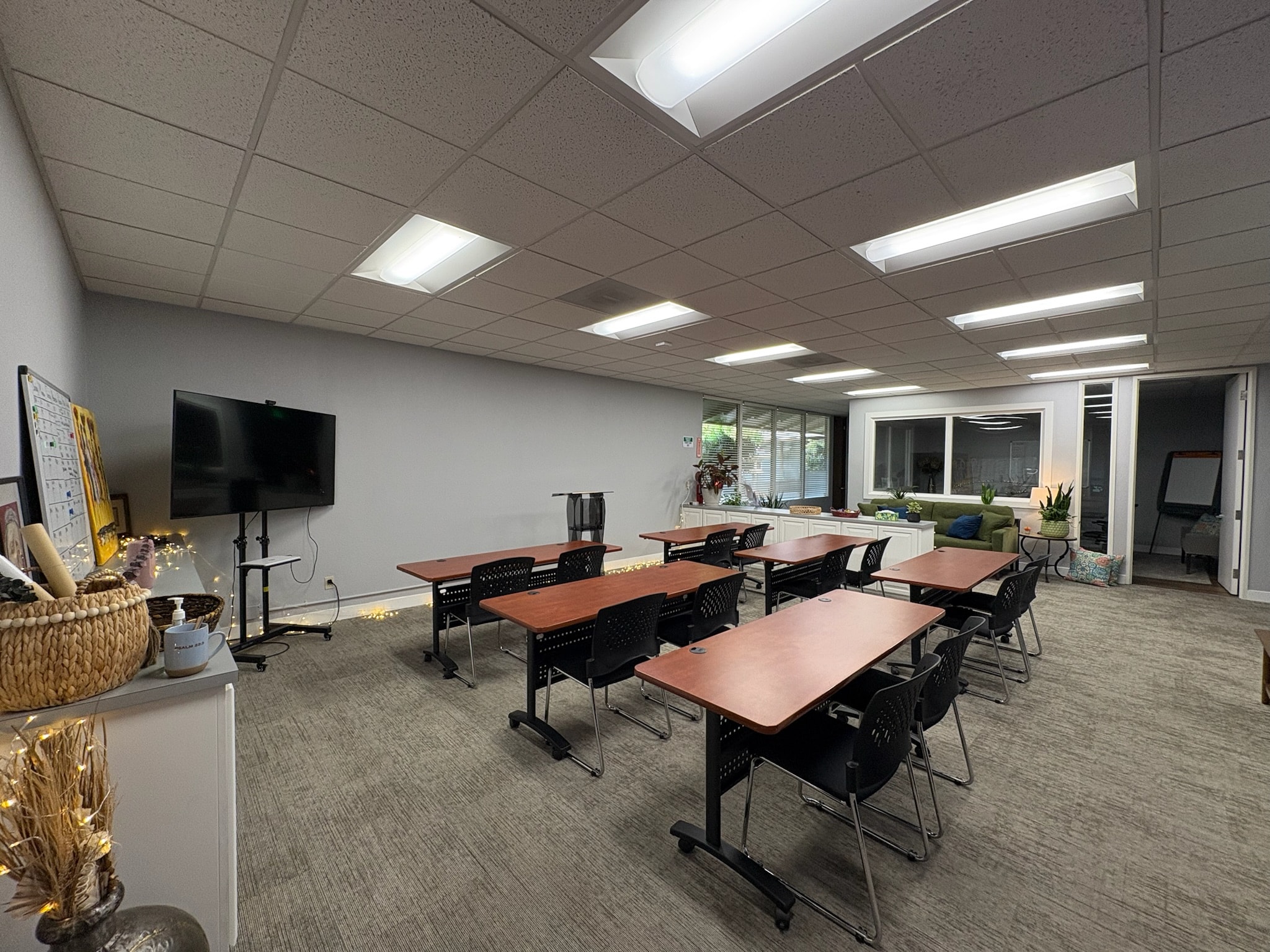 Suite 600 classroom setup with individual tables and wall-mounted TV at Consulting, E.T.C. Sacramento — training room rental